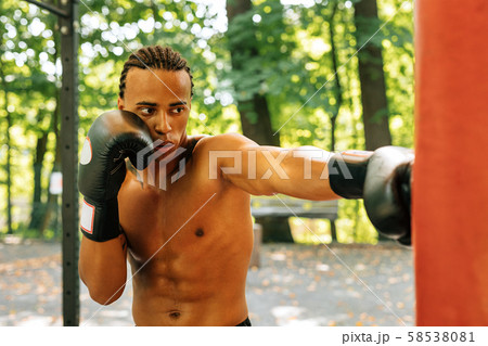 Exhausted kickboxer leaning on a punching bag Exhausted kickboxer leaning on a punching bag 58538081