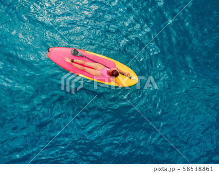 Attractive woman on stand up paddle board on a quiet blue ocean. Sup surfing in tropical sea Attractive woman on stand up paddle board on a quiet blue ocean. Sup surfing in tropical sea 58538861