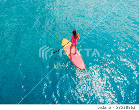 Attractive woman on stand up paddle board on a quiet blue ocean. Sup surfing in tropical sea Attractive woman on stand up paddle board on a quiet blue ocean. Sup surfing in tropical sea 58538862