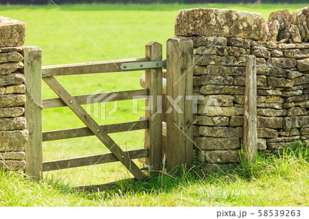 Rustic gate in drystone wall in Bibury England UK. 58539263