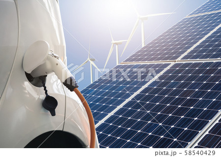 Close up of electric car with a connected charging cable on the background of solar panels and wind turbines - sources of clean renewable energy Close up of electric car with a connected charging cable on the background of solar panels and wind turbines - sources of clean renewable energy 58540429
