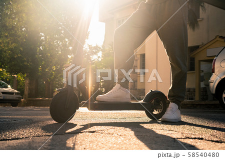 A man with electric scooter on the street 58540480