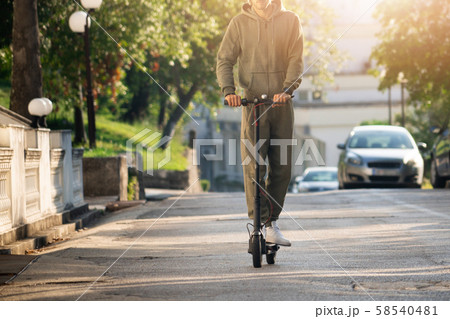 A man with electric scooter on the street 58540481