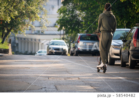 A man with electric scooter on the street 58540482