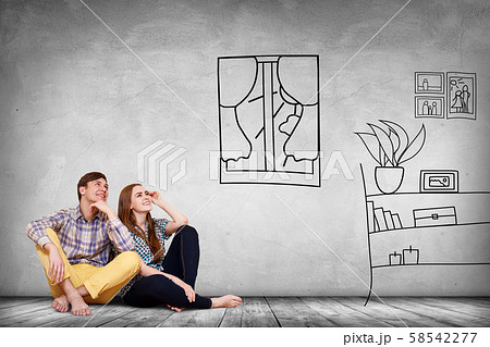 Happy couple sitting on the floor among painted furniture on the wall. 58542277