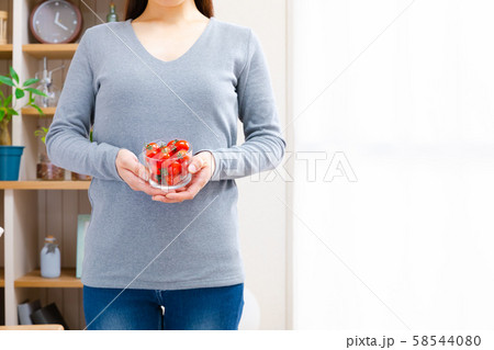 ミニトマトを持つ女性 58544080
