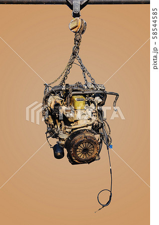 The old engine of the car hung on the hoist. The old engine of the car hung on the hoist. 58544585
