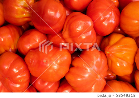 Ripe meaty fresh harvest tomatoes in one pile, macro vegetable photo for background, with glazed 58549218