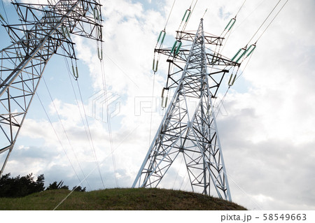 Two transmission towers in front of cloudy sky 58549663
