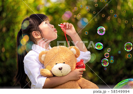 Asian girl play a bubble from soap in out door Asian girl play a bubble from soap in out door 58549994