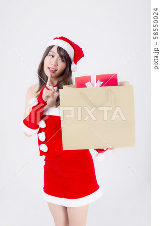 Beautiful portrait young asian woman happy and excited holding paper bag with gift box in xmas 58550024