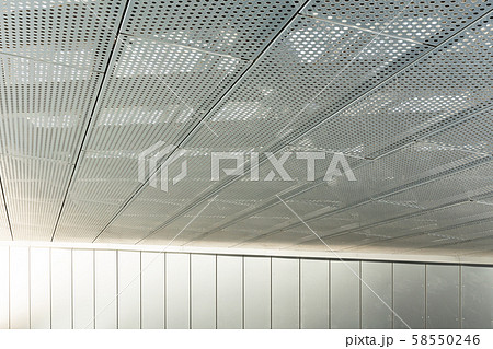 Diagonal view of metall grilles and round holes in metal ceiling surface, perforated panels Diagonal view of metall grilles and round holes in metal ceiling surface, perforated panels 58550246