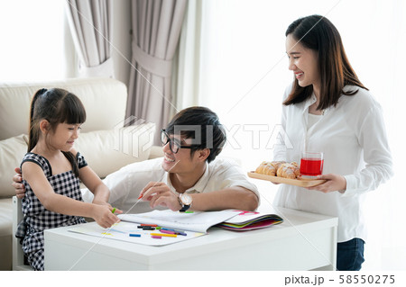 Asian family do homework togather in living room 58550275