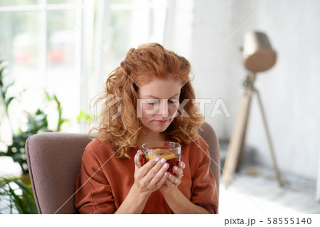 Woman holding cup of hot tea while having cold 58555140