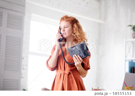 Woman having business call while working from home Woman having business call while working from home 58555153