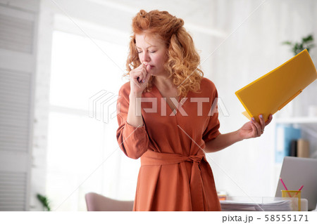Red-haired woman having strong cough at work Red-haired woman having strong cough at work 58555171