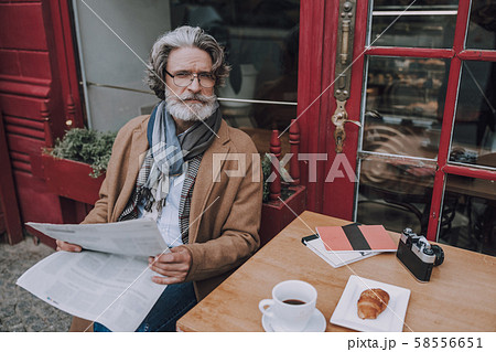 Thoughtful man with newspaper looking away stock photo Thoughtful man with newspaper looking away stock photo 58556651