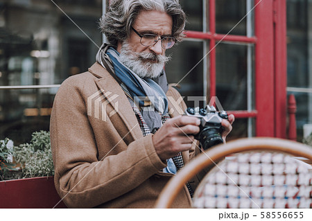 Mature traveler checking photos in camera stock photo Mature traveler checking photos in camera stock photo 58556655