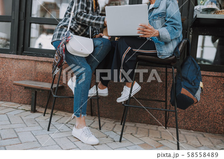 Two colleagues working on a laptop outdoors 58558489