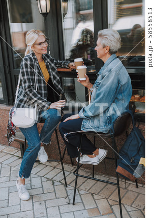 Two smiling ladies sitting in a cafe Two smiling ladies sitting in a cafe 58558513