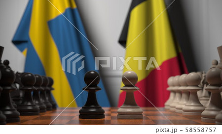 Flags of Sweden and Belgium behind pawns on the chessboard. Chess game or political rivalry related 58558757