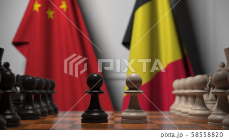 Flags of China and Belgium behind pawns on the chessboard. Chess game or political rivalry related 58558820