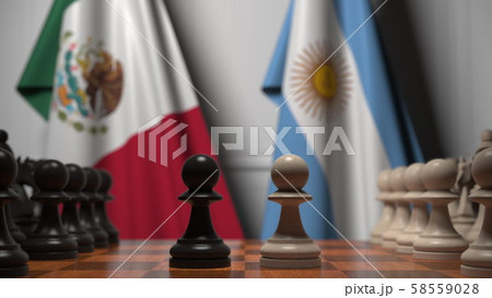 Flags of Mexico and Argentina behind pawns on the chessboard. Chess game or political rivalry Flags of Mexico and Argentina behind pawns on the chessboard. Chess game or political rivalry 58559028