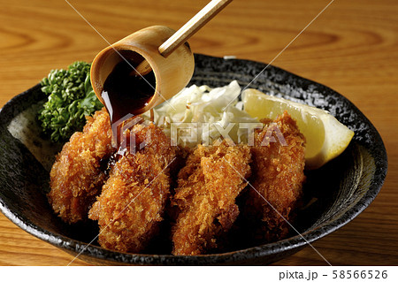 牡蠣フライにソースをかける 58566526
