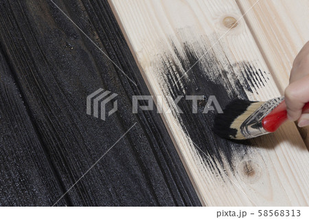 painting a wooden Board in black. black paint and 58568313