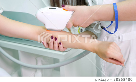 experienced therapist makes laser epilation on lady hand experienced therapist makes laser epilation on lady hand 58568480