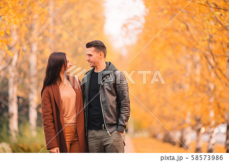 Happy family walking in autumn park on sunny fall day Happy family walking in autumn park on sunny fall day 58573986