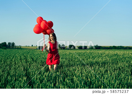 Freedom happy woman running with red balloons on green summer field Freedom happy woman running with red balloons on green summer field 58575237