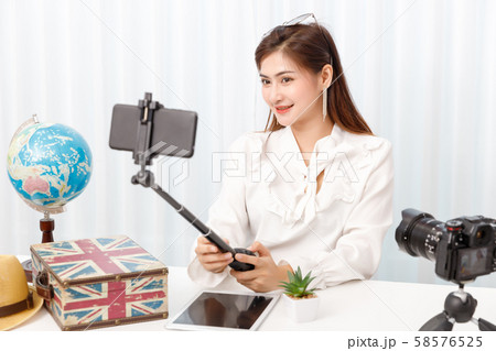 Young travel blogger girl reviewing in front of 58576525