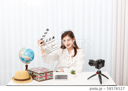 Young travel blogger girl reviewing in front of 58576527