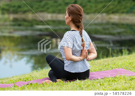 Young beautiful woman doing yoga exercise in green park. Healthy lifestyle and fitness concept. 58578226