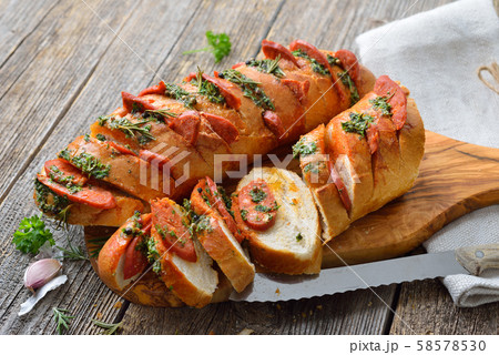 Spanish food: Roasted bread with herb butter and hot Chorizo salami fresh from the oven 58578530