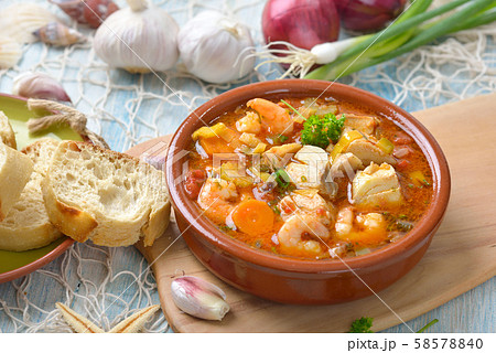 Mediterranean fish soup served with fresh white bread 58578840
