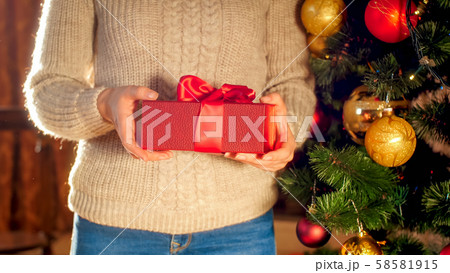Closeup image young woman holding red Christmas gift box with big ribbon bow 58581915