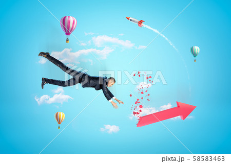 Young businessman in sky falling down trying to catch red broken graph arrow, with hot air balloons Young businessman in sky falling down trying to catch red broken graph arrow, with hot air balloons 58583463