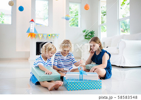 Space theme kids birthday party. Boy with present. Space theme kids birthday party. Boy with present. 58583548