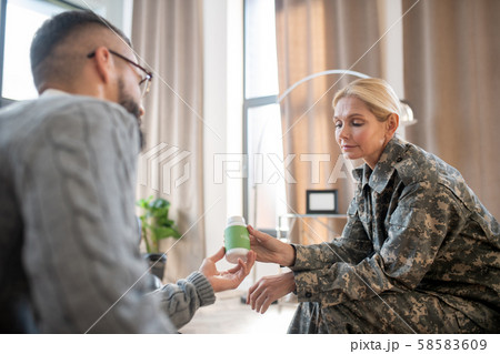 Psychologist giving antianxiety pills for military woman Psychologist giving antianxiety pills for military woman 58583609