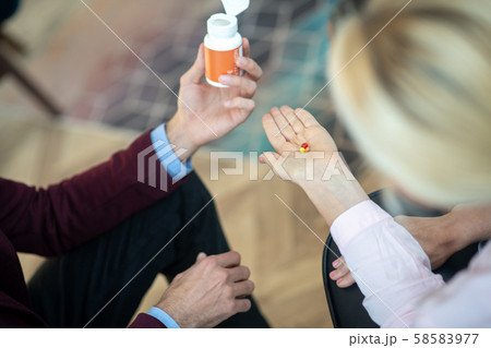 Top view of blonde stressed woman taking antianxiety pills 58583977