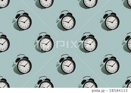 Many black classic style alarm clock isolated on green background 58584115
