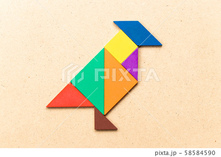 Color tangram puzzle in shape on wood background Color tangram puzzle in shape on wood background 58584590