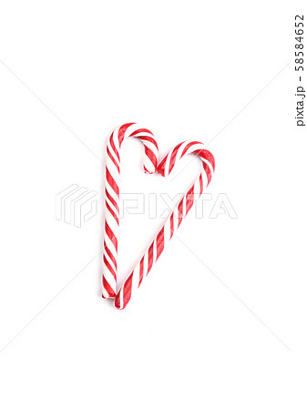 Two red caramel canes in the shape of a heart for Christmas and New Year. 58584652