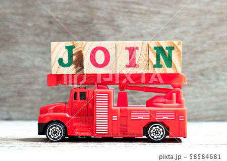Toy fire ladder truck hold letter block in word join on wood background 58584681