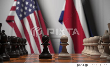 Flags of USA and Costa Rica behind pawns on the chessboard. Chess game or political rivalry related Flags of USA and Costa Rica behind pawns on the chessboard. Chess game or political rivalry related 58584867