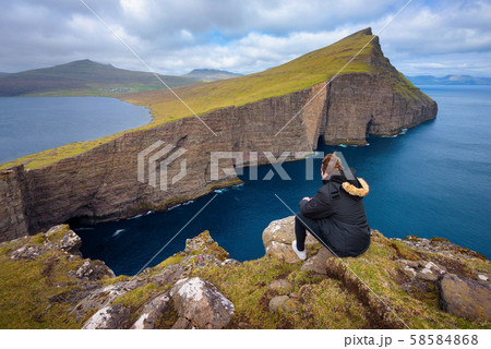 Hiker looking at the lake Sorvagsvatn on Faroe Islands 58584868
