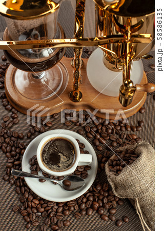 two cup with black coffee and geyser coffeepot 58586135