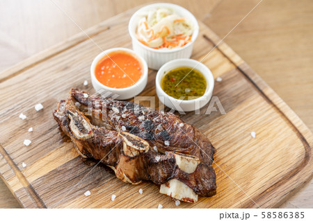 Beef meat cut according to the Argentine style, called asado. with Pickled cabbage and two sauces Beef meat cut according to the Argentine style, called asado. with Pickled cabbage and two sauces 58586385